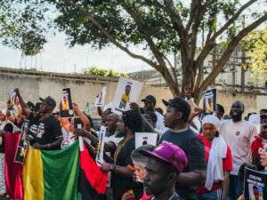 Manifestantes da comunidade senegalesa e movimentos sociais seguram cartazes com a foto do bebê Abdoulaye Dieng e dizeres de justiça durante protesto em São Paulo.