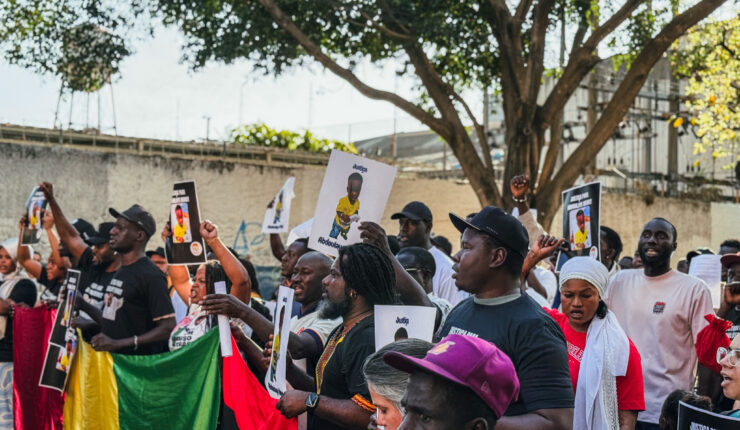 Manifestantes da comunidade senegalesa e movimentos sociais seguram cartazes com a foto do bebê Abdoulaye Dieng e dizeres de justiça durante protesto em São Paulo.